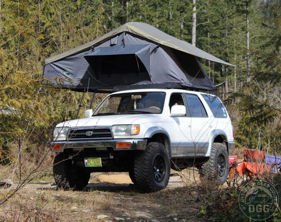 Overland Vehicle Systems Nomadic 3 roof top tent mounted on a 4x4 in the woods